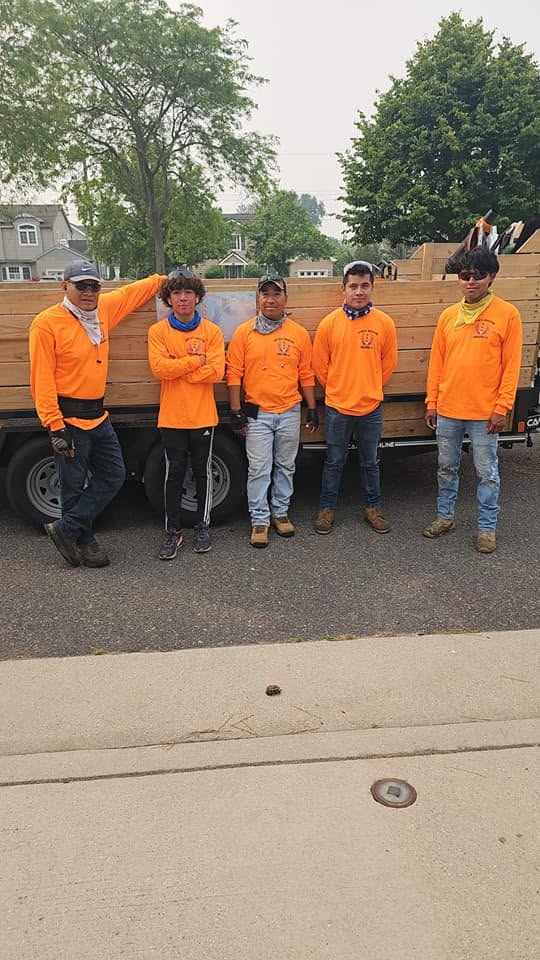 New Days Adventure Landscaping crew members in NDA uniforms in front of the company trailer
